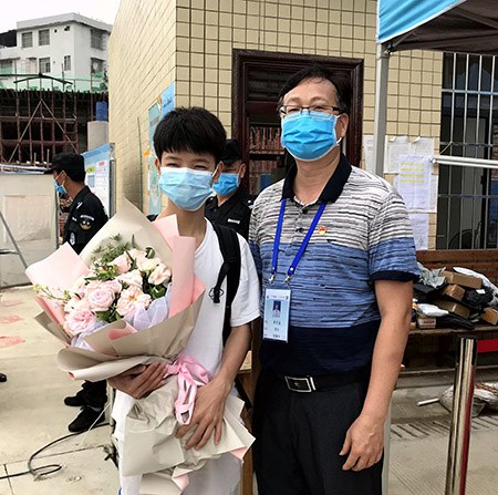 2.黄杰品校长给第一名返校的同学送上鲜花.jpg