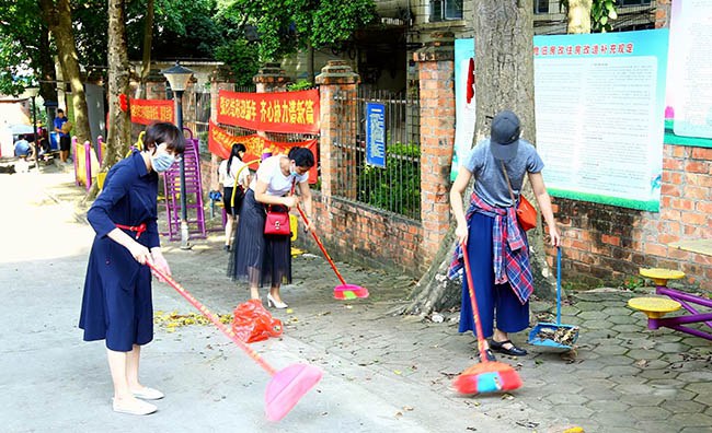 青年教职工打扫生活区大门道路.JPG