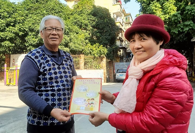 工作人员向居民发放宣传单.jpg