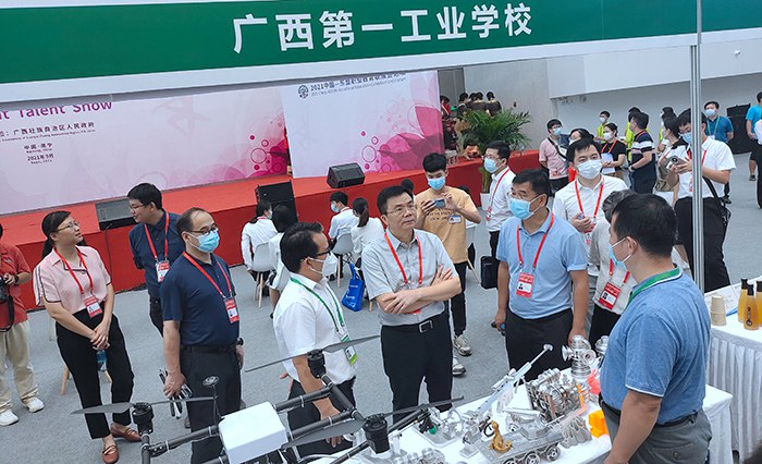 自治区教育厅副厅长黄雄彪（中）、自治区教育厅职业教育与成人教育处处长覃壮才（右）参观我校展位.jpg