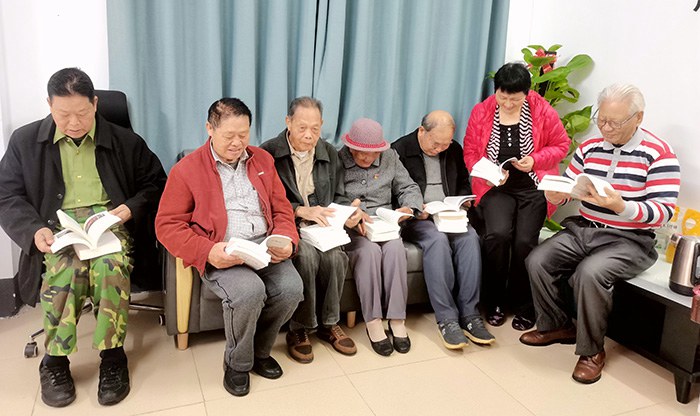 退休老党员们正在认真阅读党史书籍.jpg